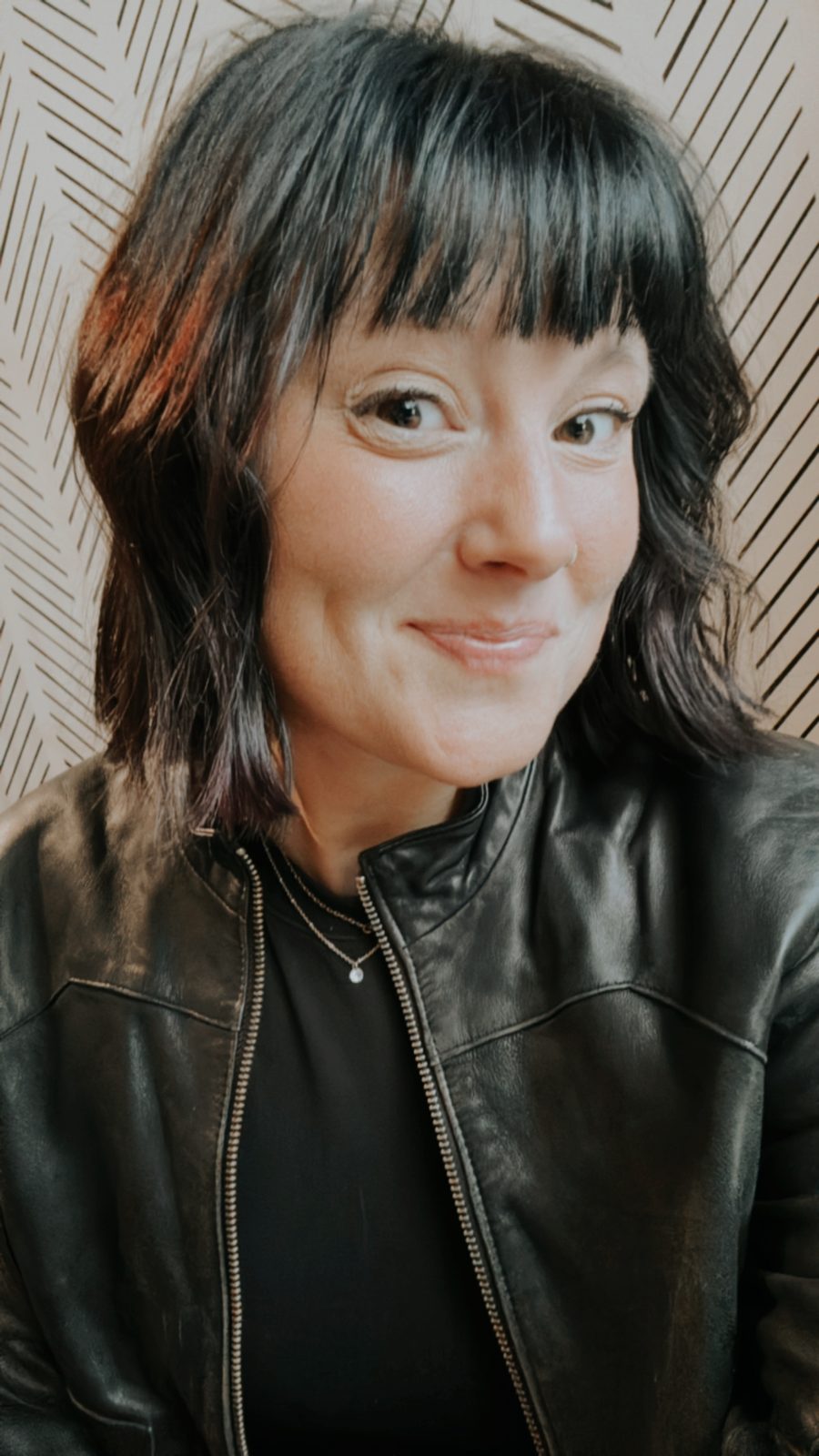 Brittany King smiling in a black leather jacket
